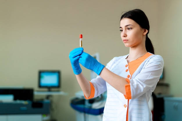 Portrait of pretty female laboratory assistant analyzing a blood sample