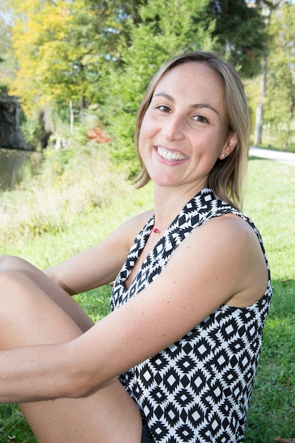 Photo portrait of a pretty happy woman sit in garden park