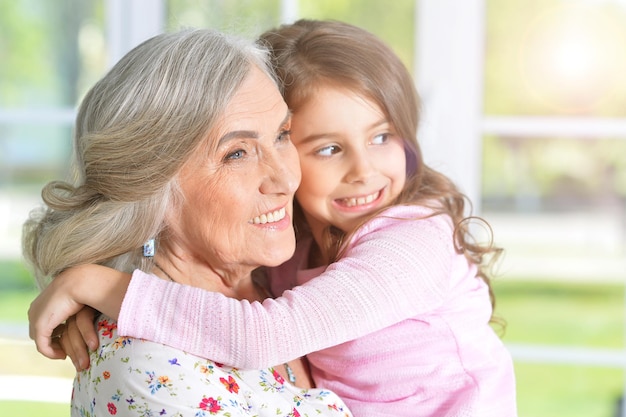 Portrait of pretty little girl hugging her grandmother