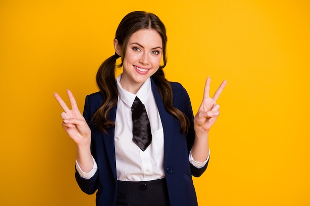 portrait of  pretty lovely cheerful teen schoolgirl showing double v-sign