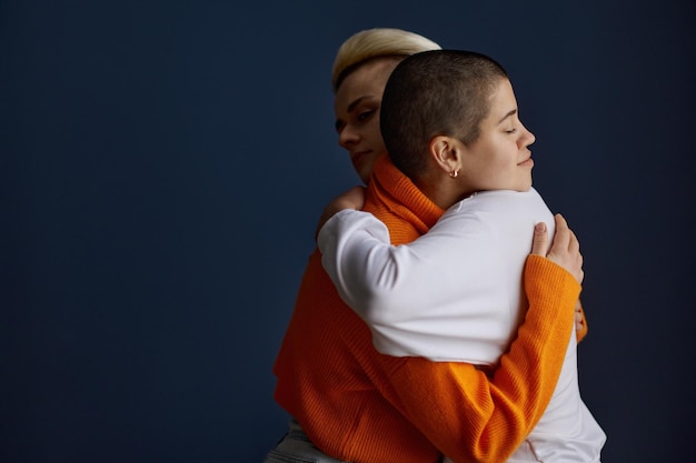 Portrait of pretty positive lesbian woman in friendly embrace. Young lgbt lovers hugging feeling love and friendship. Homosexual relationship acceptance concept