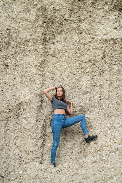 Portrait of pretty slim woman standing in front of sand quarry