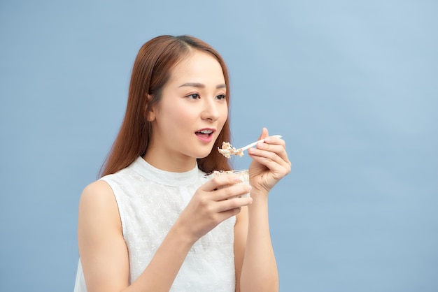 Portrait of pretty smiling fit girl having yogurt raisins and oatmeal