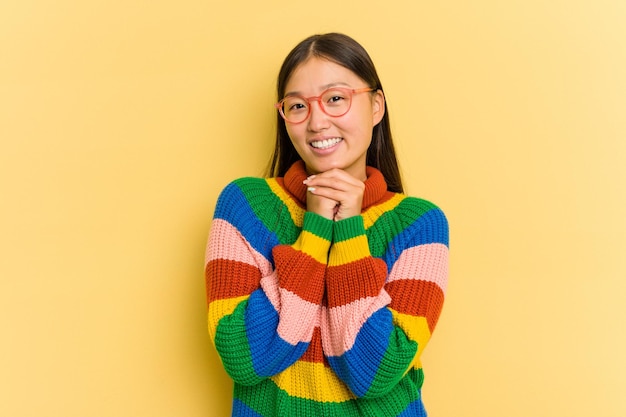 Portrait of pretty young Asian woman isolated on yellow background