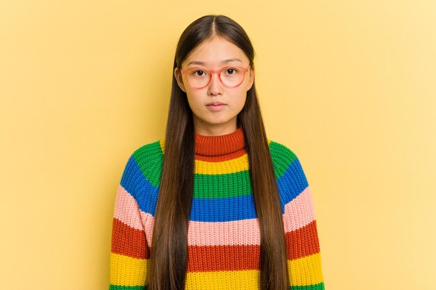 Portrait of pretty young Asian woman isolated on yellow background