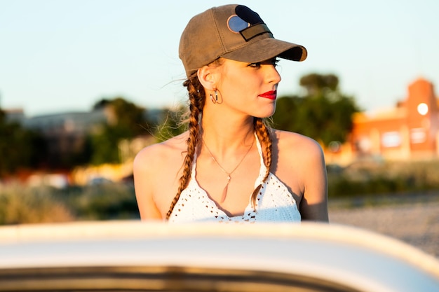 Portrait of pretty young woman driving on road trip on beautiful summer day.