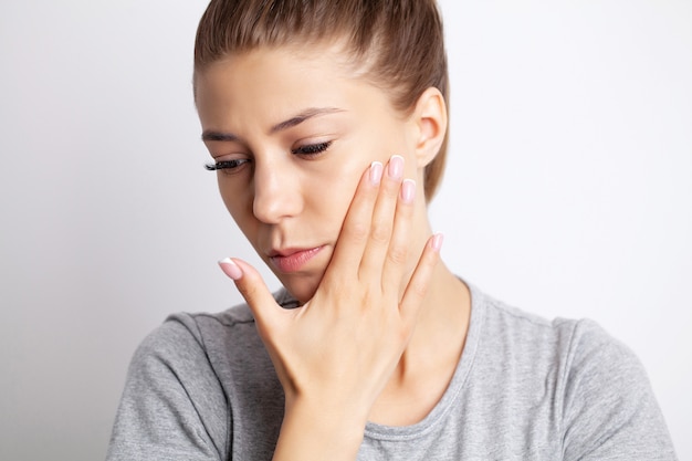 Portrait of a pretty young woman having a severe toothache