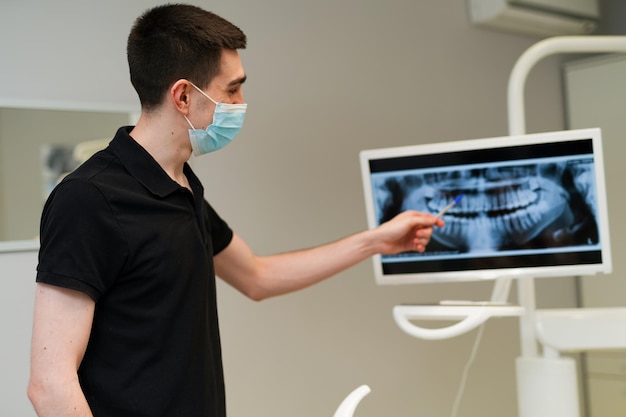 Portrait of professional dentistry doctor. Young handsome dental specialist in modern hospital ward.