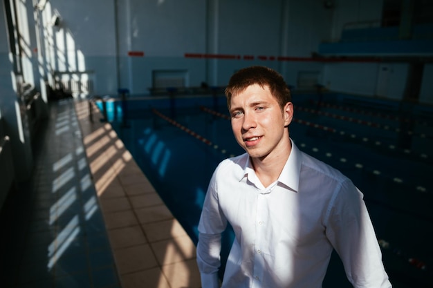 Portrait of a professional swimmer sportsman at the pool in the white shirt