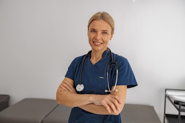 Portrait of professional woman doctor with stethoscope on her workplace in hospital