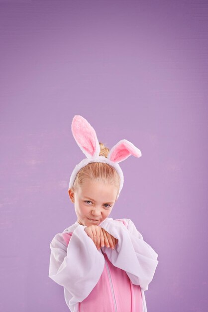 Photo portrait rabbit and girl with costume happy and halloween outfit on a purple studio background face kid and model with bunny clothes and character with holiday and easter with culture and funny