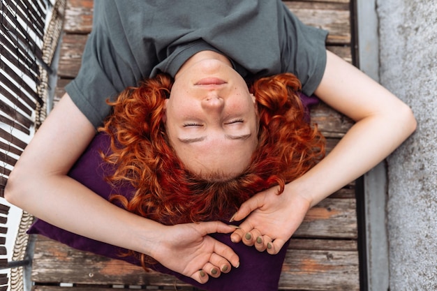 Photo portrait redhaired curly young woman enjoying relaxation on balcony or terrace