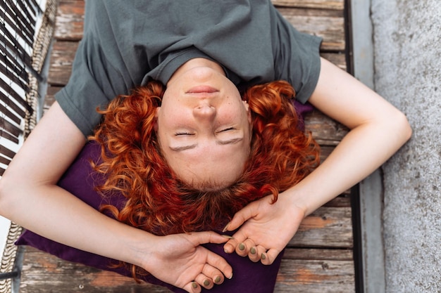 Photo portrait redhaired curly young woman enjoying relaxation on balcony or terrace