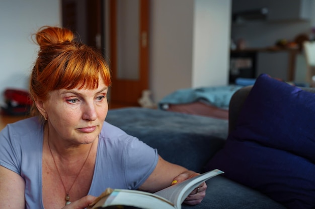 Portrait redhaired woman reading novel book