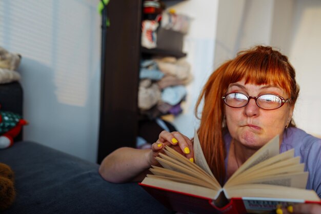 Portrait redhaired woman reading novel book