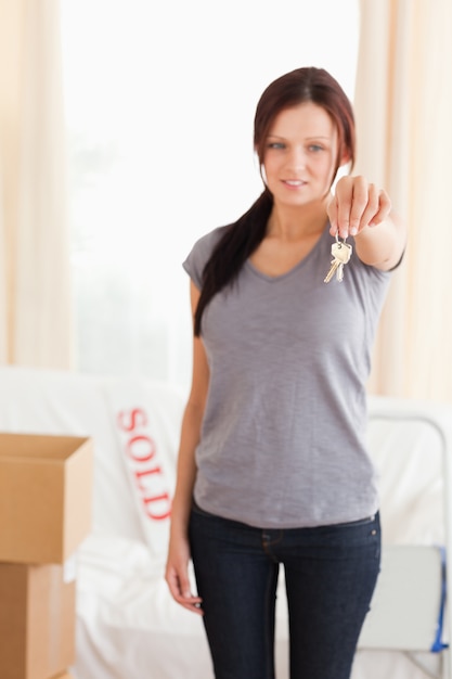 Portrait of a redheaded woman holding keys