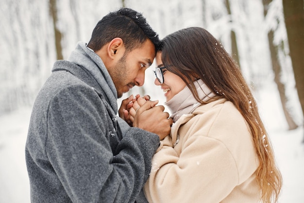 Portrait of a romantic couple spending time together in winter forest