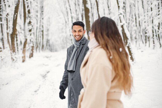 Portrait of a romantic couple spending time together in winter forest