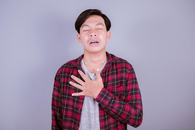 Portrait of a sad asian man on gray background