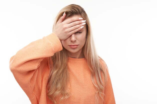 Portrait sad blonde young woman put hand on forehead isolated on white studio background Made mistake upset and depressedxA