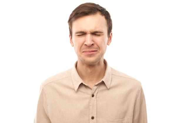 Portrait sad brunette young man isolated on white studio background Made mistake upset and depressedxA