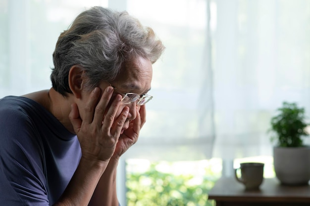 Portrait of sad and lonely Asian senior woman in living room