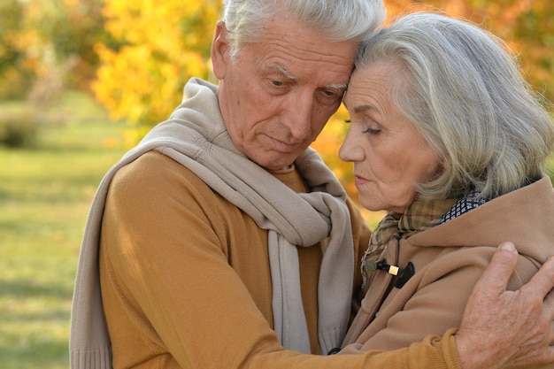 Portrait of sad senior couple in autumn park