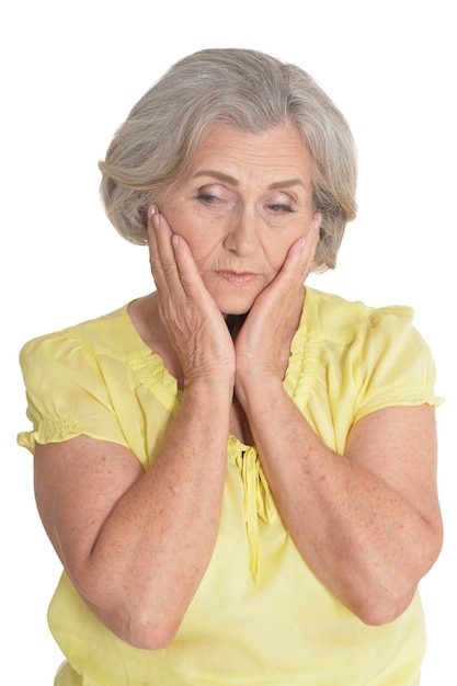 Portrait of sad senior woman posing on white background