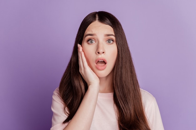 Portrait of sad unhappy woman open mouth hand cheek isolated on violet background