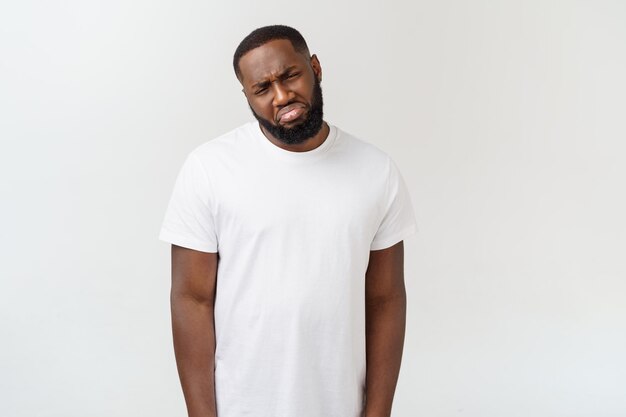 Portrait of sad young man standing against white background