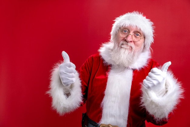 Portrait santa claus in christmas hat red suit show gesture thumb up like showing thumb up finger up