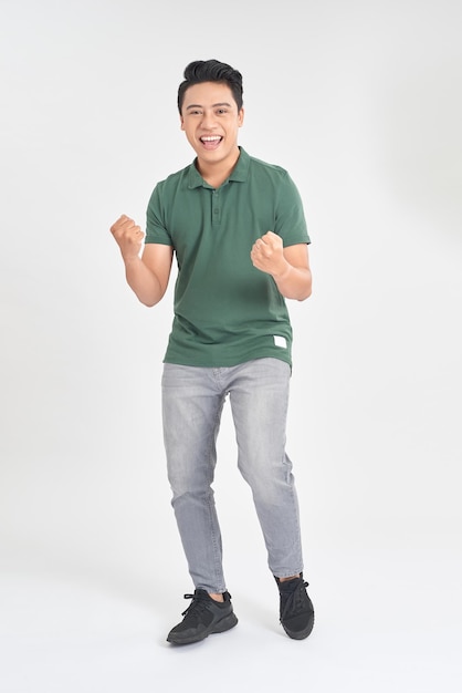 Portrait of a satisfied young man celebrating success isolated over white background