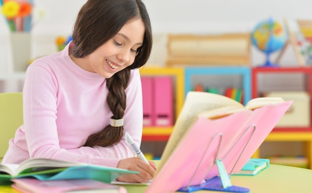 Portrait of schoolgirl doing homework in her room