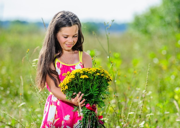 Portrait of schoolgirl among the flowers in the summer