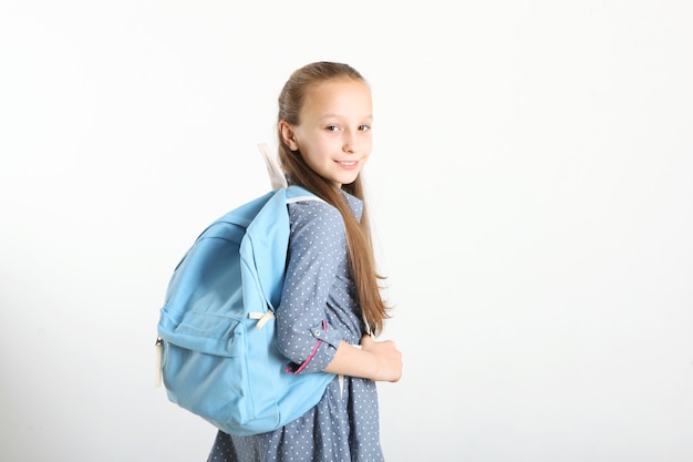 Portrait of schoolgirl with a backpack and stationery