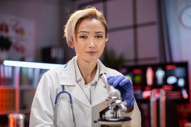 Portrait of scientist working using microscope analyzing samples