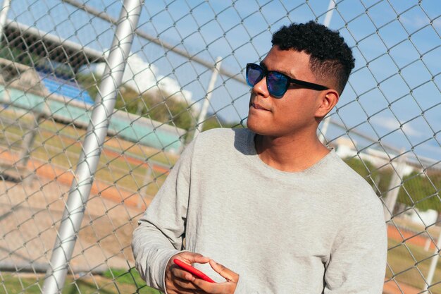 Portrait of a self-confident young man in a gray T-shirt outdoors.