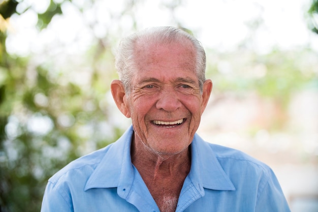 portrait of senior brazilian man looking at one spot in sunset and smiling. Horizontal shape, copy space.