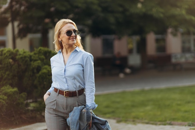 Portrait senior business professional walking outside Mature business woman walking outdoors on street Success