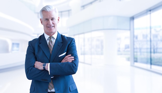 Portrait of senior businessman in front of his modern office