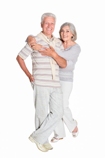 Portrait of senior couple hugging on white background