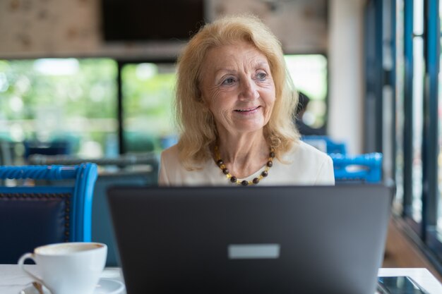 portrait Of Senior Elderly Woman Sitting And Using Laptop Computer