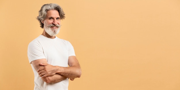 Portrait of senior man crossing arms and smiling with copy-space