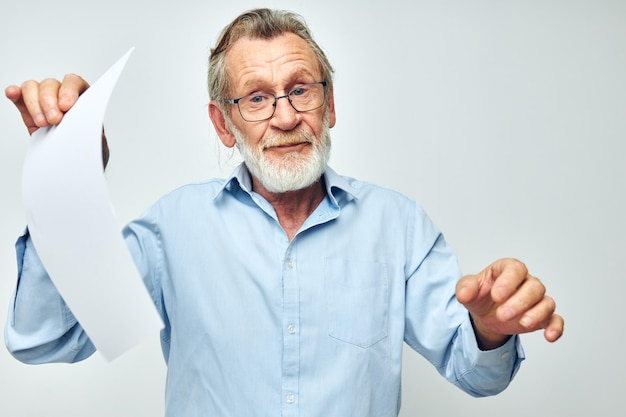 Photo portrait of senior man gesturing while standing against white background