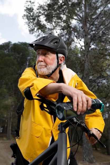 Portrait senior man with bike on mountain