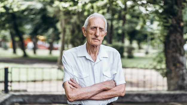 Portrait of senior man with gray hair outdoors in the city park