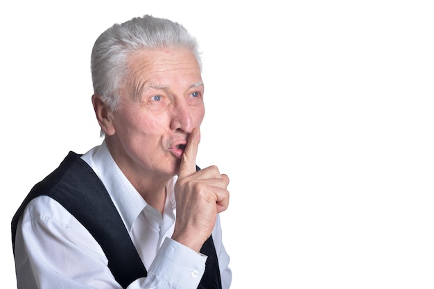 Portrait of senior man with silence gesture on white background