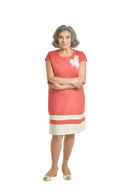 Portrait of senior woman in red dress on white background