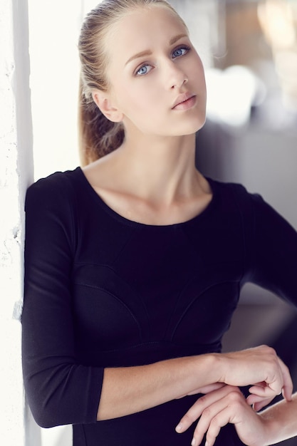 Portrait of sensual blond female in black dress.