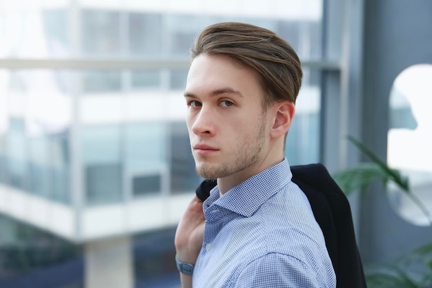 Portrait of serious confident young man businessman in formal clothes shirt looking at camera in business centre office building Business person people concept